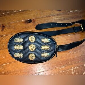 Faux leather black fanny pack with gold accents including beetles and lions